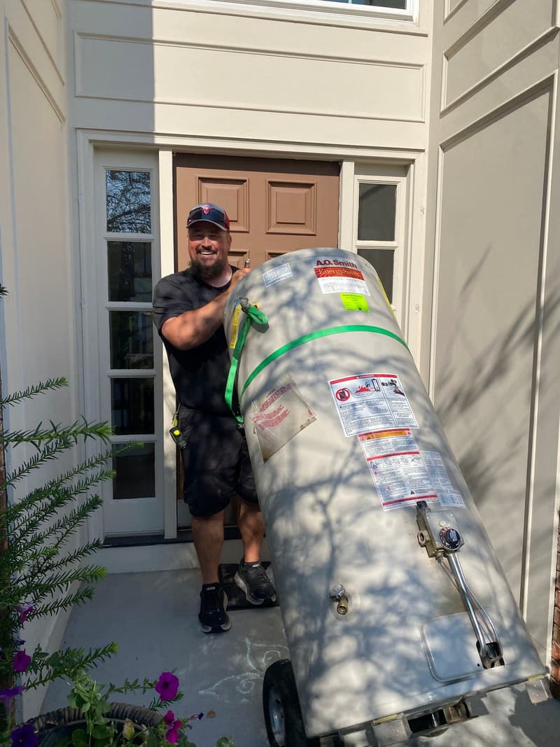 Worker moving a water heater on a dolly